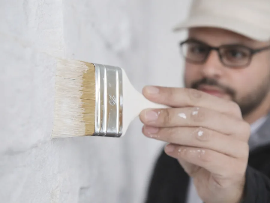 Maler streicht eine Wand mit dem Pinsel